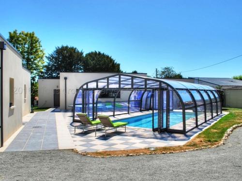 une serre avec deux chaises et une piscine dans l'établissement Grande maison moderne avec piscine à Tours, proche du centre-ville et de la Loire à Vélo - FR-1-381-231, à Tours