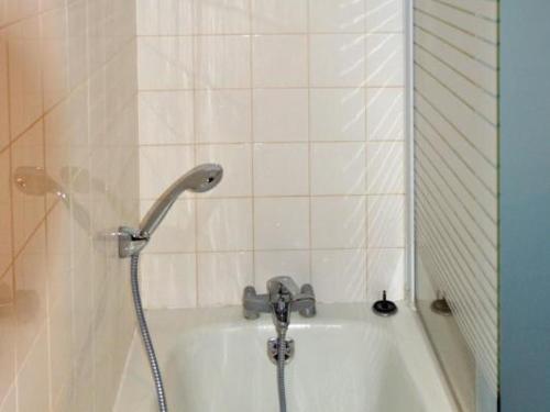 a bath tub with a shower head in a bathroom at Maison de campagne avec jardin privé, proche Châteaux de la Loire et Futuroscope. - FR-1-381-288 in Chaveignes