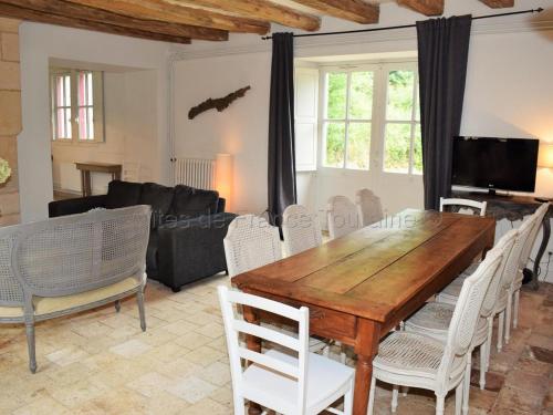 un salon avec une table et des chaises en bois dans l'établissement Élégante Demeure 17e avec Spa, Sauna et Authentique Cheminée, proche Châteaux de la Loire - FR-1-381-348, à Les Essards