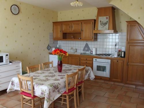 une cuisine avec une table avec un vase de fleurs dessus dans l'établissement Maison de vacances de charme au cœur du Val de Loire, proche châteaux, jardin, tout équipée, Wi-Fi. - FR-1-381-486, à Lerné
