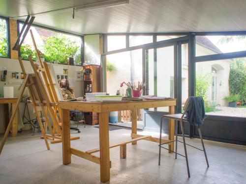une pièce avec une table en bois avec un tableau dans l'établissement Charmante maison proche Châteaux de la Loire, jardin privé, parfait pour couples et familles - FR-1-381-371, à Athée-sur-Cher