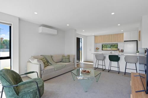 a living room with a couch and a table at Lux Local Living in Christchurch