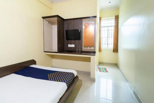a small room with a bed and a tv at Hotel O SK Lodge in Kumbalgod