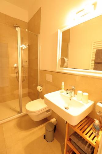a bathroom with a sink and a toilet and a mirror at Inselhuus Norderney in Norderney
