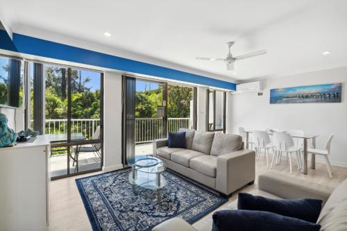 a living room with a couch and a table at Smugglers On The Beach in Coffs Harbour