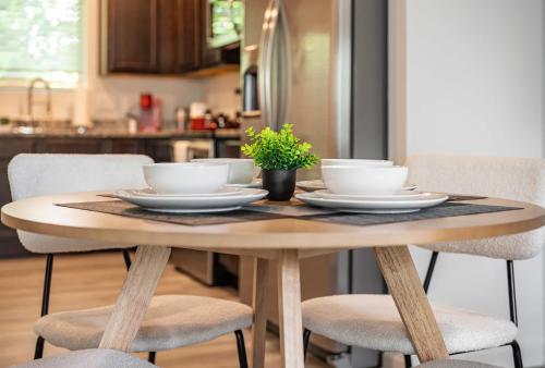 una mesa de madera con cuencos y platos en la cocina en Upscale King 3BR Townhouse Mins to Cary & NC State, en Raleigh