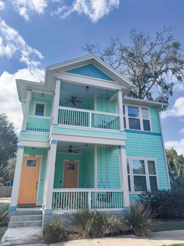 a blue house with a balcony on a street at The Orange Blossom Suite Near UF Shands D-town in Gainesville