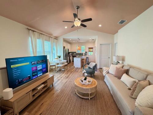 a living room with a large flat screen tv at The Orange Blossom Suite Near UF Shands D-town in Gainesville