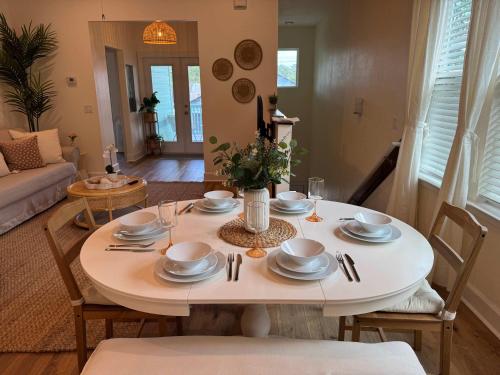 a table with plates and dishes on it in a living room at The Orange Blossom Suite Near UF Shands D-town in Gainesville