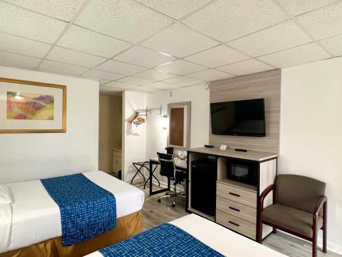 a hotel room with two beds and a flat screen tv at Travelodge by Wyndham Hershey in Hershey