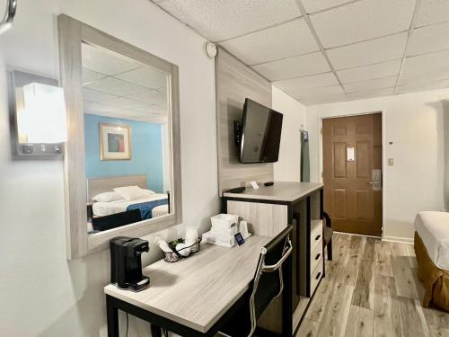 a room with a desk and a mirror at Travelodge by Wyndham Hershey in Hershey