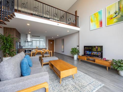 a living room with a couch and a table at Hi-Home Suites - Penstudio Westlake Hanoi in Hanoi
