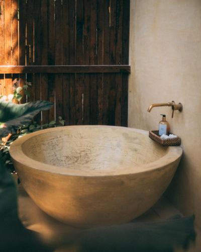 a wooden bath tub in a bathroom with a window at Villa Jivanaya in Isda Islet
