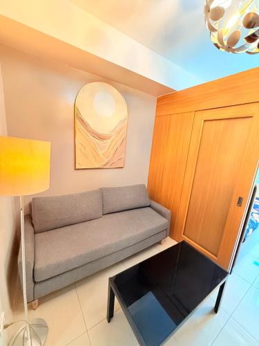 a living room with a couch and a table at Shell Residences Condotel by PauL in Manila