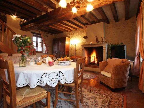 une salle à manger avec une table et une cheminée dans l'établissement Gîte familial avec grand jardin fleuri, cheminée et activités extérieures, proche Petite Cité de Caractère - FR-1-497-38, à Saint-Jouin-de-Blavou