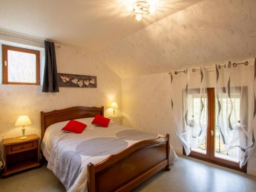 une chambre avec un lit avec des oreillers rouges et une fenêtre dans l'établissement Charmante maison indépendante avec jardin, proche de Sarlat, Dordogne, idéale pour 6 personnes - FR-1-616-44, à Saint-Vincent-le-Paluel