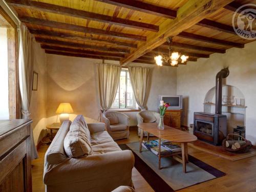 a living room with a couch and a table at Gîte spacieux avec cheminée, jardin, équipements bébé et animaux acceptés, proche nature et randonnée. - FR-1-496-128 in Saint-Martin-la-Sauveté