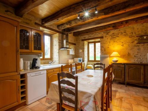 une cuisine avec une table et des chaises dans une pièce dans l'établissement Maison périgourdine rénovée proche Le Bugue, grand jardin, 3 chambres - FR-1-616-50, à Journiac