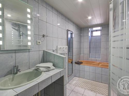 une salle de bain avec une baignoire, un lavabo et une douche dans l'établissement Gîte confortable avec jardin clos et wifi - FR-1-496-171, à Champoly