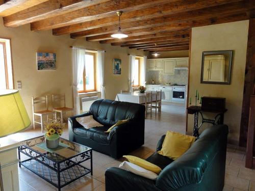 Il comprend un salon doté d'un mobilier en cuir et une cuisine. dans l'établissement Maison périgourdine 2 chambres à Salignac-Eyvigues avec cour et jardin, animaux acceptés - FR-1-616-5, à Salignac Eyvigues