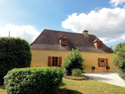 a large yellow house with a black roof at Charmante maison périgourdine avec jardin, cheminée et proche de Sarlat - FR-1-616-88 in Salignac Eyvigues