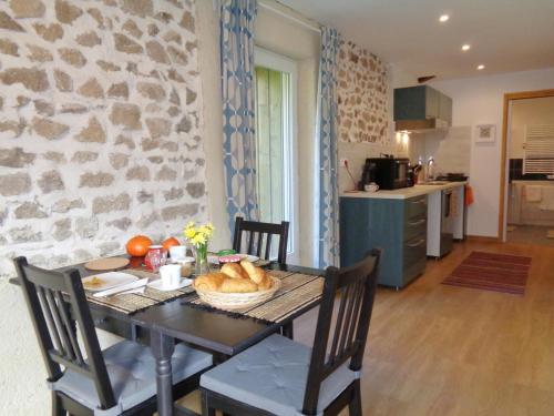 - une table avec un panier de pain dans la cuisine dans l'établissement Studio Montagne avec Terrasse Privative, Wifi, Près de Sentiers de Randonnée, Animaux Acceptés - FR-1-496-224, à Saint-Priest-la-Prugne