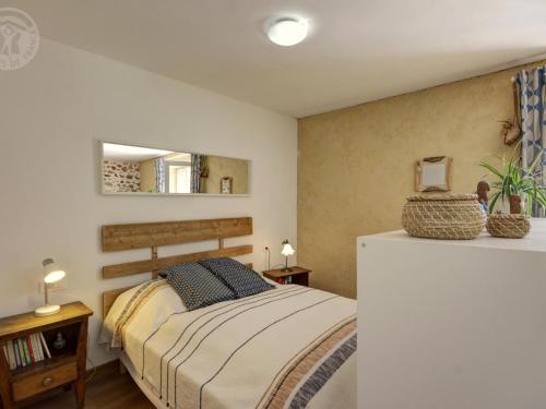 ein Schlafzimmer mit einem Bett und einem Spiegel in der Unterkunft Studio Montagne Paisible, Terrasse, Animaux Bienvenus - FR-1-496-224 in Saint-Priest-la-Prugne