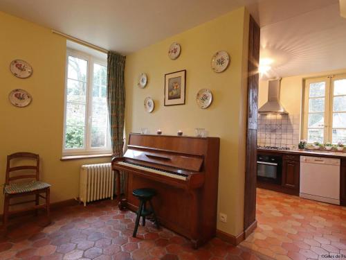 a kitchen with a piano in a room at Charmante Maison dans Aile de Château du 18ème avec Jardin et Proximité Étangs, Forêt, Loisirs - FR-1-497-13 in Le Grais