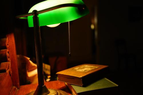 a green lamp sitting on a table next to a book at Imperial Hotel + Restaurant in Amador City