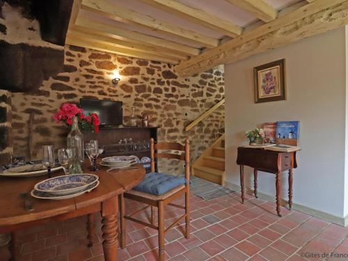 une salle à manger avec une table et un piano dans l'établissement Maison historique arborée avec jardin et étang privés, idéale pour un couple - FR-1-497-135, à La Carneille