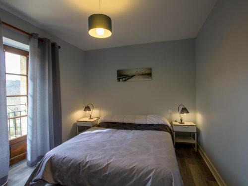 une chambre avec un lit et deux tables de nuit avec lampes dans l'établissement Maison en pierre rénovée avec jardin, proche Sarlat, idéale pour familles, avec équipements bébé inclus - FR-1-616-200, à Aillac