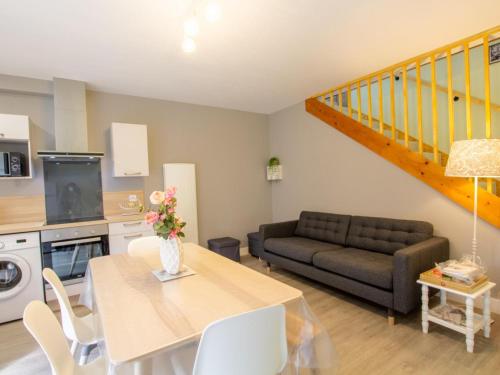 un salon avec une table et un canapé dans l'établissement Maison en pierre rénovée avec jardin, proche Sarlat, idéale pour familles, avec équipements bébé inclus - FR-1-616-200, à Aillac