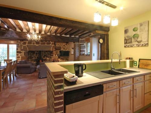 a kitchen with a sink and a living room at Maison écologique du XVe siècle avec jardin clos et garage, idéale pour une escapade paisible - FR-1-497-7 in La Baroche-sous-Lucé