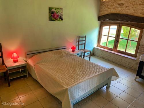- une chambre avec un lit, 2 tables et 2 fenêtres dans l'établissement Maison familiale près de la Dordogne avec jardin, barbecue, équipements bébé et sites touristiques à proximité - FR-1-616-168, à Saint-Chamassy