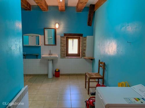 une salle de bain bleue avec un lavabo et un miroir dans l'établissement Maison familiale près de la Dordogne avec jardin, barbecue, équipements bébé et sites touristiques à proximité - FR-1-616-168, à Saint-Chamassy