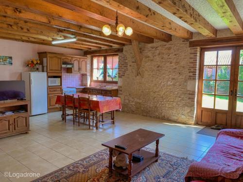 un salon avec une table et une cuisine dans l'établissement Maison familiale près de la Dordogne avec jardin, barbecue, équipements bébé et sites touristiques à proximité - FR-1-616-168, à Saint-Chamassy