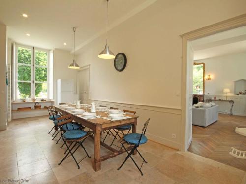 une salle à manger avec une table, des chaises et une horloge dans l'établissement Château élégant avec grand parc, animaux, cheminée, jeux, et tout confort dans le Perche - FR-1-497-102, à Bellavilliers