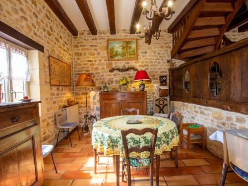 une salle à manger avec une table et des chaises dans l'établissement Maison en pierre avec grand jardin, terrasse, cheminée, proche des sites préhistoriques des Eyzies - FR-1-616-174, à La Mouthe