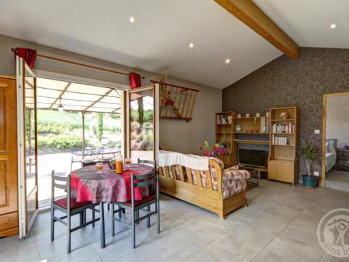 un salon avec une table et une chambre dans l'établissement Gîte tout équipé avec terrasse, jardin et prestations de qualité près de Genilac - FR-1-496-114, à Genilac