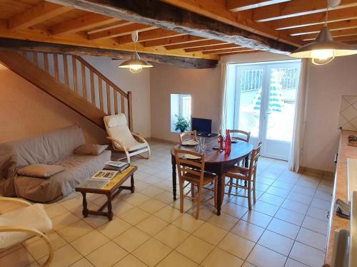 un salon avec une table et un canapé dans l'établissement Gîte paisible avec jardin privatif, proche Loire et balades, pour 11 personnes, animaux acceptés - FR-1-496-86, à Saint-Paul-de-Vézelin