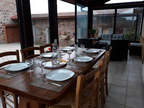 une table en bois avec des assiettes et des verres à vin dessus dans l'établissement Gîte panoramique avec jardin et cour fermée, proche Roanne et lac des sapins, idéal nature et calme - FR-1-496-233, à Saint-Victor-sur-Rhins