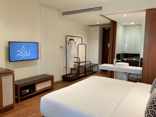 a bedroom with a bed and a sink and a television at Hotel Loy Chiang Mai in Chiang Mai