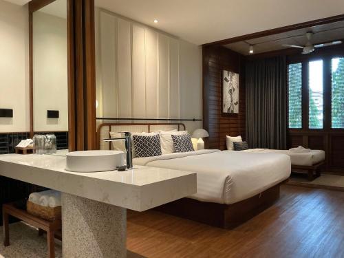 a bedroom with a large bed and a sink at Hotel Loy Chiang Mai in Chiang Mai