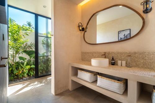 ein Badezimmer mit Waschbecken und Spiegel in der Unterkunft Dreamy 2BR pool villa, steps from Gili Air beach in Gili Air