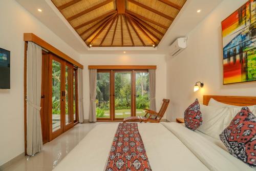 a bedroom with a bed and a large window at Arca Jungle View Luxury Villa Ubud in Ubud