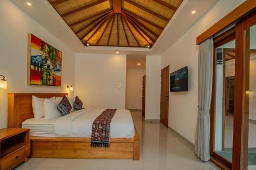 a bedroom with a large bed and a ceiling at Arca Jungle View Luxury Villa Ubud in Ubud