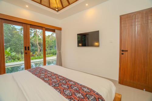 a bedroom with a bed and a large window at Arca Jungle View Luxury Villa Ubud in Ubud