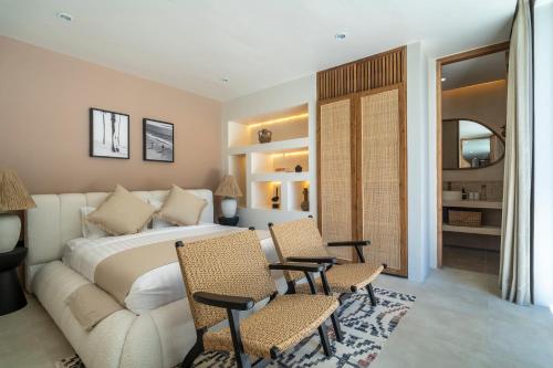 ein Schlafzimmer mit einem Bett, Stühlen und einem Sofa in der Unterkunft Dreamy 2BR pool villa, steps from Gili Air beach in Gili Air