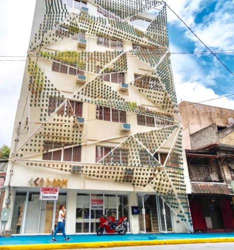 a building with a person walking past it at Jardin Oriental Suites Ubelt Manila in Manila