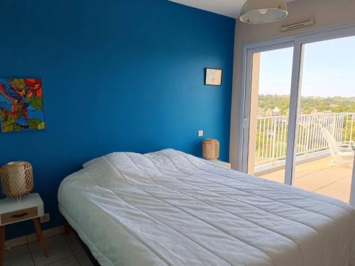 - une chambre bleue avec un lit et un balcon dans l'établissement Villa avec terrasse à 400m de la mer à Pleumeur-Bodou - FR-1-368-400, à Pleumeur-Bodou